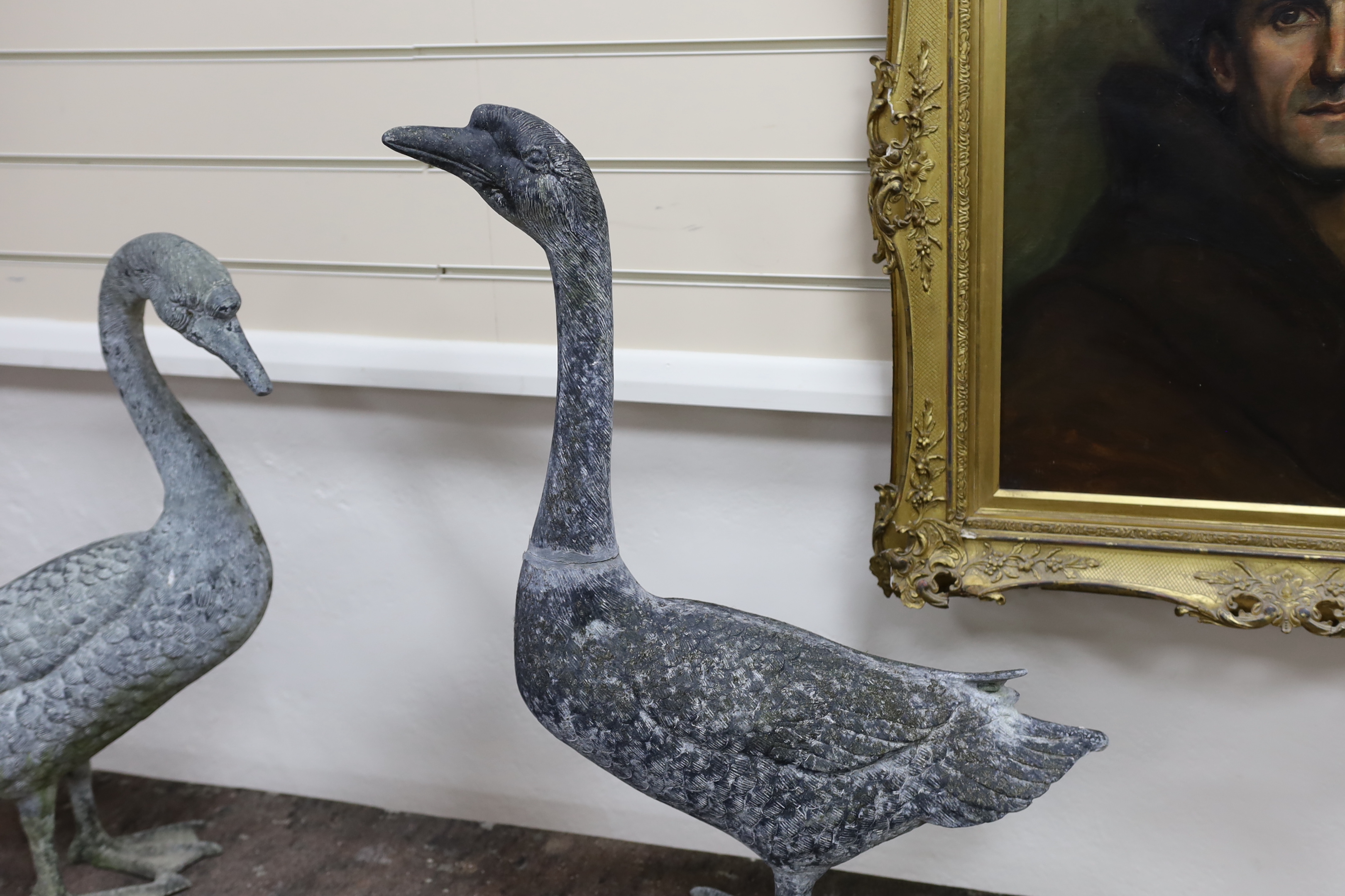 A pair of cast metal garden ornaments modelled as geese, larger height 71cm